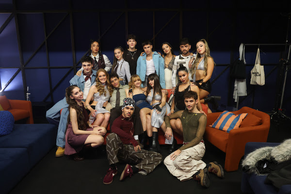 Foto de grupo del elenco de OT 2025 posando en un set con sofás naranjas y azules