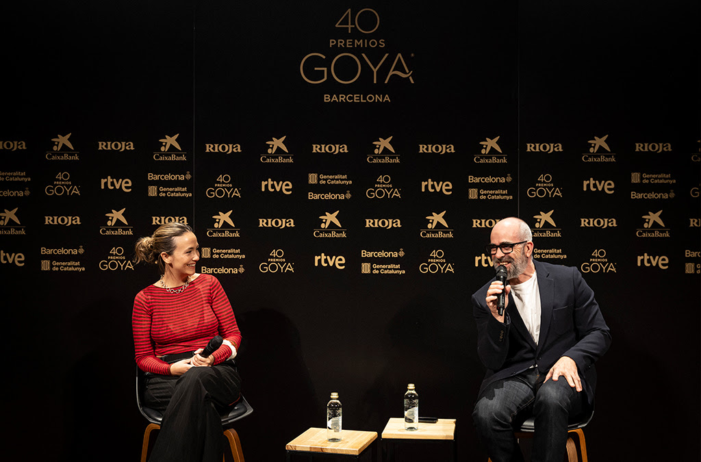 Presentadores de los 40 Premios Goya en Barcelona – El Grillo Amarillo Rueda de prensa de los 40 Premios Goya en Barcelona: dos presentadores conversan con micrófono ante el fondo corporativo de RTVE, CaixaBank y Rioja